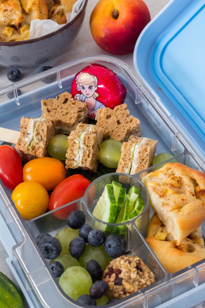 Gesunde Lunchbox für Kinder - Lecker gefüllte Brotdose mit Brotspießen, Trauben, Heidelbeeren, Tomaten, Käse und Apfel-Zimtschnecken. Lieblingszwei.de